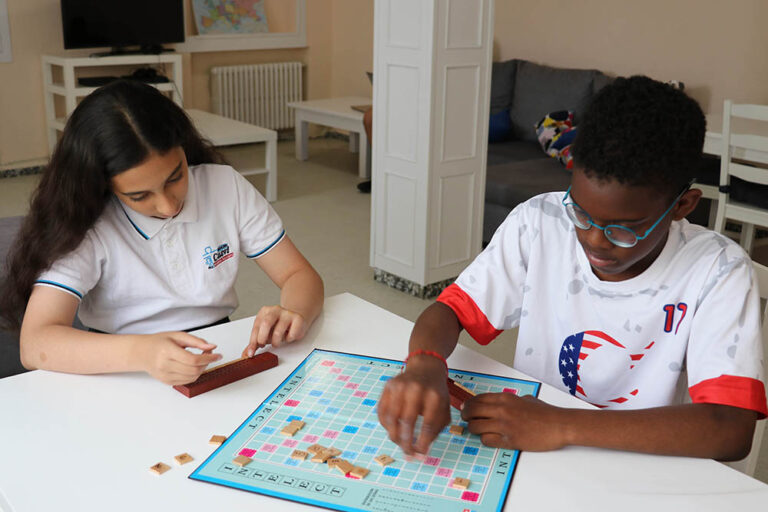 Niños jugando a un juego de mesa en el salón de una residencia de estudiantes. Internacionalidad. Residencia en Casvi International American School. Internados en España