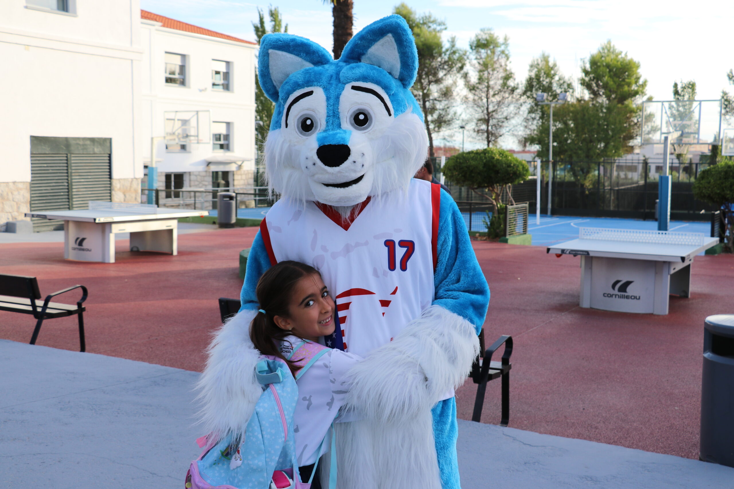 Una niña abrazando a la mascota del colegio en Casvi International American School en su primer día de colegio