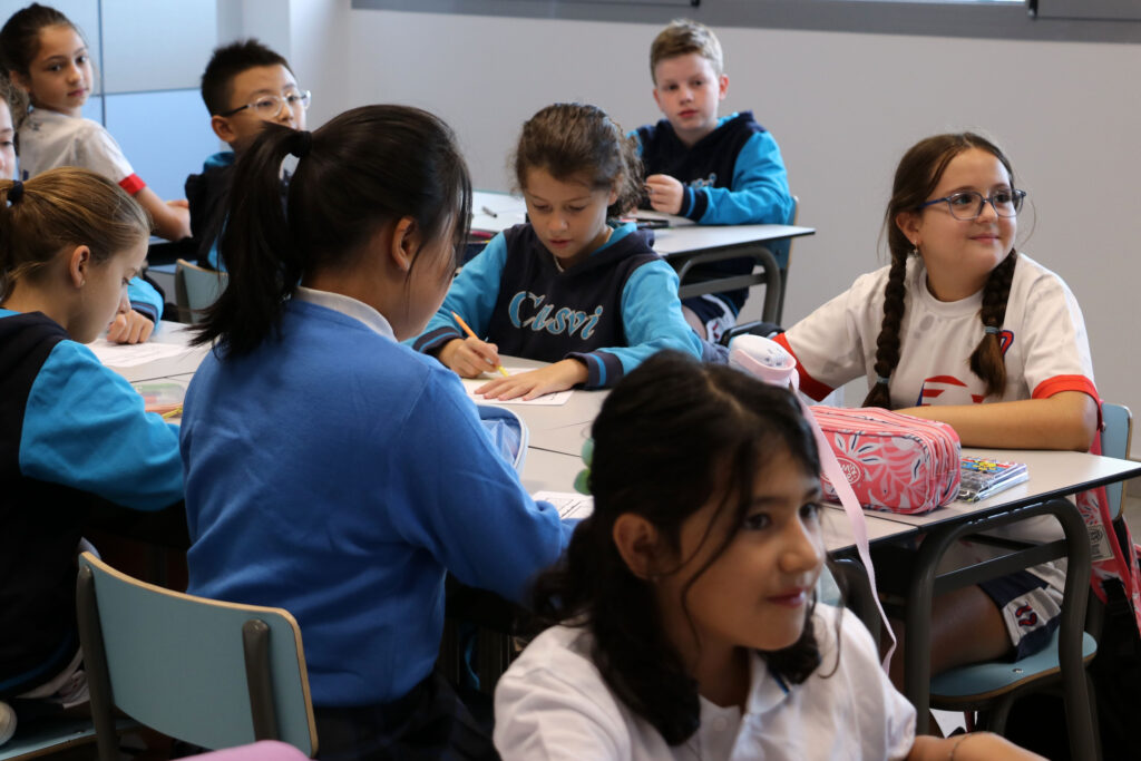 Clase de Grade 5 de Casvi International American School en su primer día de curso escolar. Niños sentados y atendiendo, mirando a la pizarra