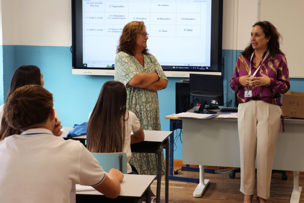 Virginia Caballero, directora de Casvi International American School, junto a una profesora y la pizarra de una clase de Diploma Programme, dando un discurso sobre los retos de la educación en el primer día de curso