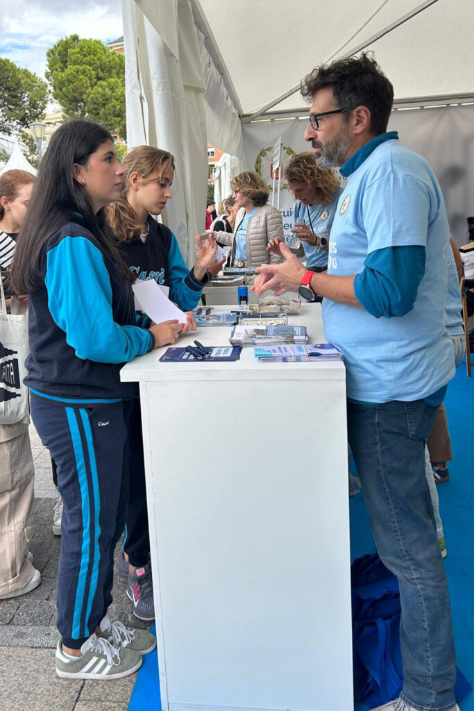 Dos alumnas de Casvi International American School en una feria de orientación organizada por el ayuntamiento en un stand de una universidad escuchando atentamente sobre orientación vocacional