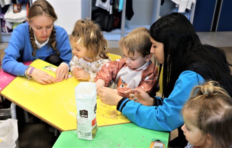 Grupo de niños pequeños haciendo actividades sensoriales para bebés. Los niños están concentrados en la actividad sensorial