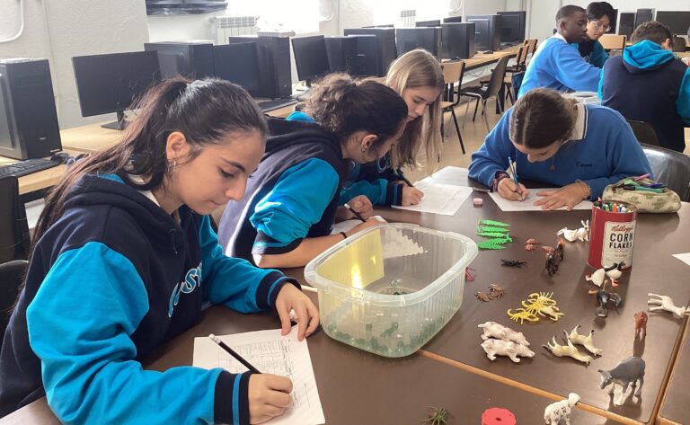 Un grupo de estudiantes del Colegio Casvi Tres Cantos está realizando una actividad educativa en la que combinan el aprendizaje práctico con la organización de datos. Utilizando figuras de animales y otros elementos, clasifican y recopilan información en sus hojas de trabajo. La actividad fomenta la observación, la colaboración y el desarrollo de habilidades de organización y análisis, reflejando el enfoque práctico del colegio en el aprendizaje.