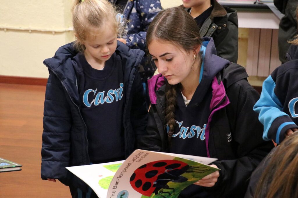 Actividad de una alumna de CAS contándole un cuento a una niña pequeña