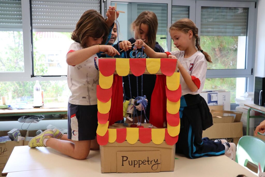 Grupo de alumnas jugando con un teatro de marionetas en Casvi Tres Cantos