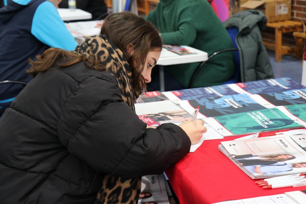 Alumna rellenando un impreso de una universidad