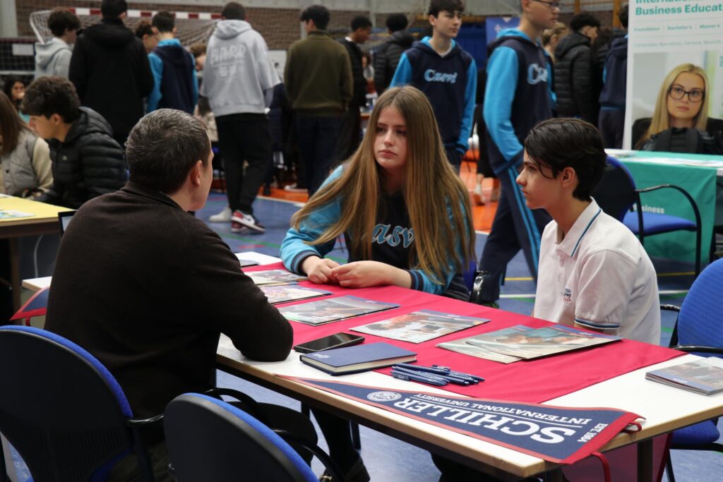 Alumnos escuchando la información en la feria de universidades