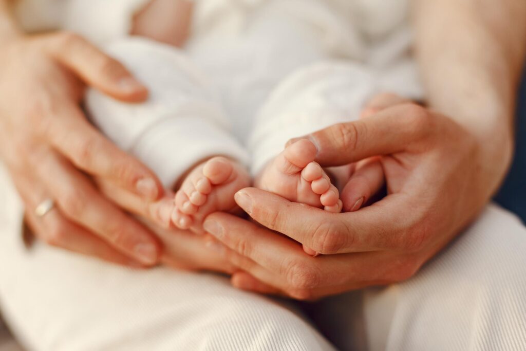 Manos de una madre primeriza abrazando los pies de su bebé