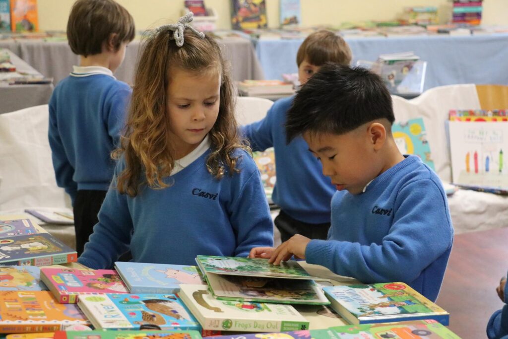 Un niño y una niña ojeando un libro en Casvi Tres Cantos