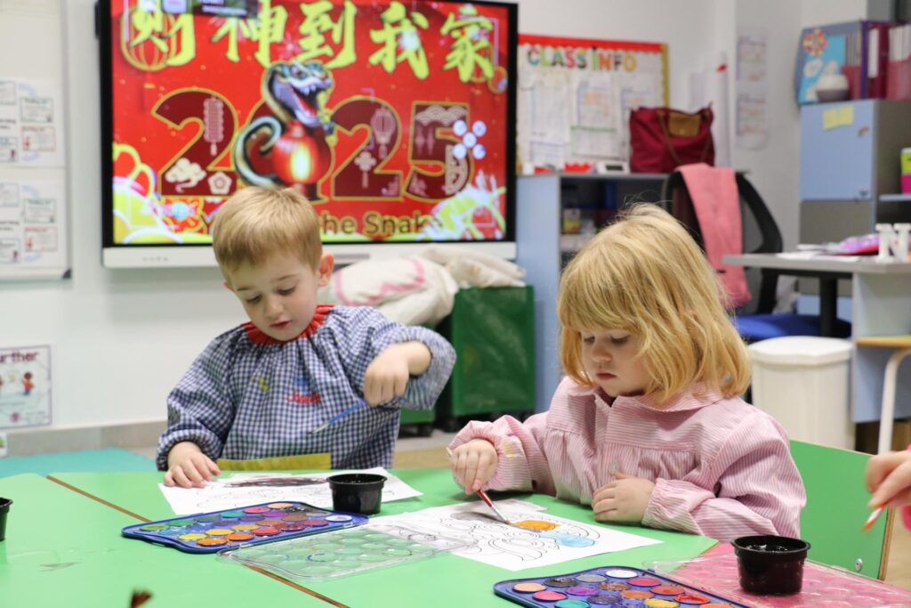 Dos niños pequeños pintando un dragón por el Año Nuevo Chino en Casvi