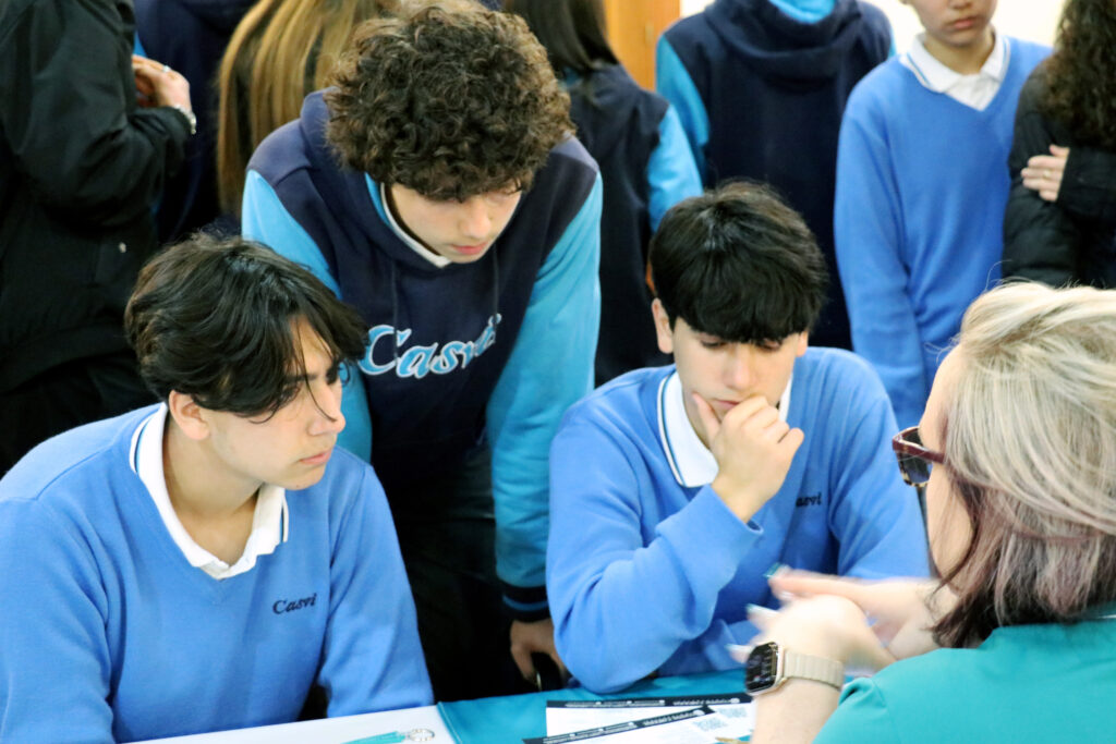 Tres estudiantes de Casvi escuchan las opciones de una universidad internacional